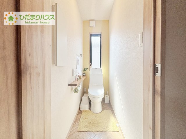 窓から自然光が差し込む明るいトイレ空間。すっきりとしたデザインに加え、収納付きカウンターを備え、使い勝手と清潔感を兼ね備えた快適な空間です。