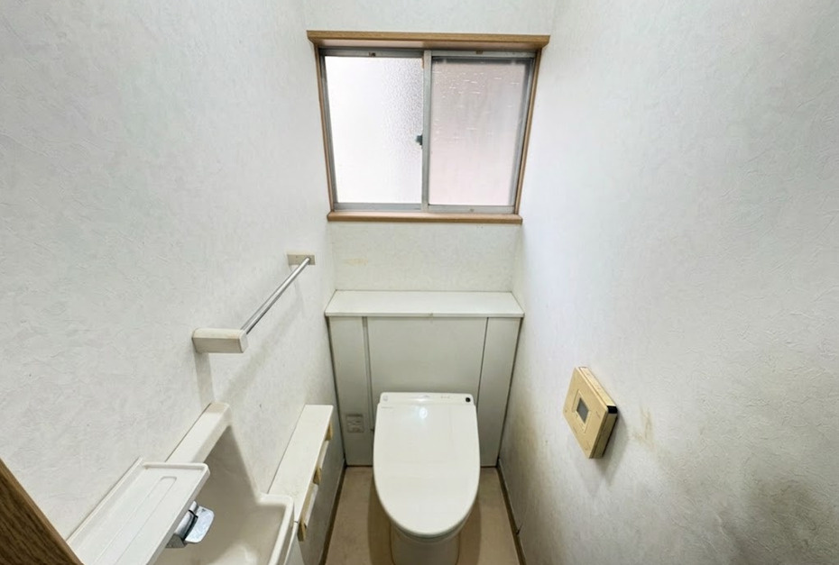 シンプルで使いやすいトイレです。窓付きのため換気や採光がしやすく、明るく清潔感のある空間となっています。壁面には小物置きとして使えるスペースもあり、実用性も確保されています。ゆとりのある空間設計です。