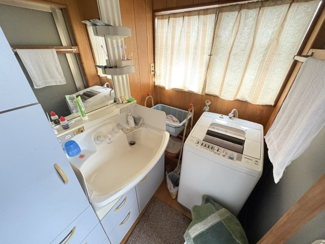 明るい光が差し込む洗面脱衣室は、木目調の温かみある空間。洗濯機置き場も確保され、家事動線がスムーズ。浴室とも近く、日常の身支度や洗濯が効率良く行える実用的なスペースです。