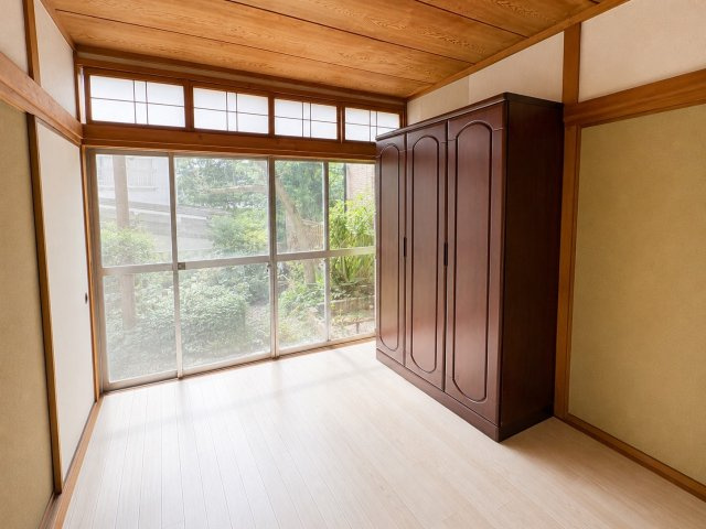 大きな窓から庭の緑を望める、落ち着いた雰囲気の6帖洋室。木を活かした天井や柱がどこか懐かしく温かな印象を与えます。収納家具も置かれており、寝室や趣味のお部屋などに活用できます。