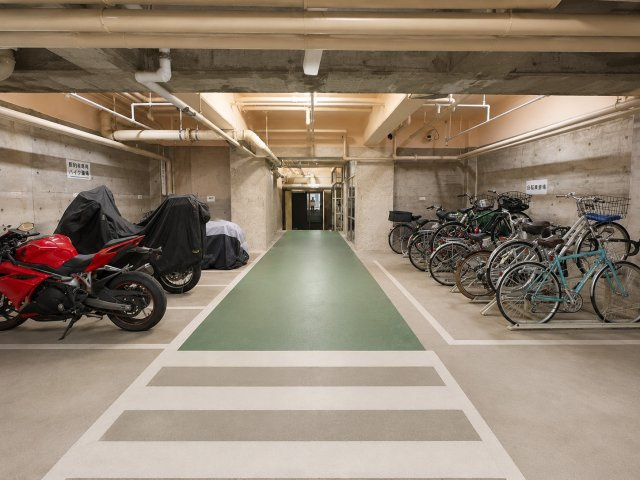 建物内に設けられた駐輪場とバイク置場です。屋根付きのため雨風の影響を受けにくく、自転車とバイクのスペースが分けられています。