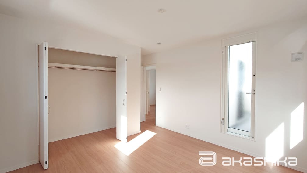 バルコニーに繋がる大きな窓から光が差し込む明るい部屋です。