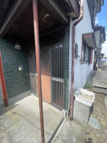 玄関前には雨除けの庇があり、壁面はタイルで仕上げられています