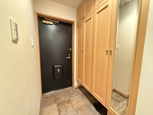 収納力のあるシューズボックスを備えた玄関スペースです。高さのある収納で家族分の靴をすっきり整理でき、玄関まわりを清潔に保てます。ミラー付きの扉もあり、お出かけ前の身だしなみチェックにも便利です。