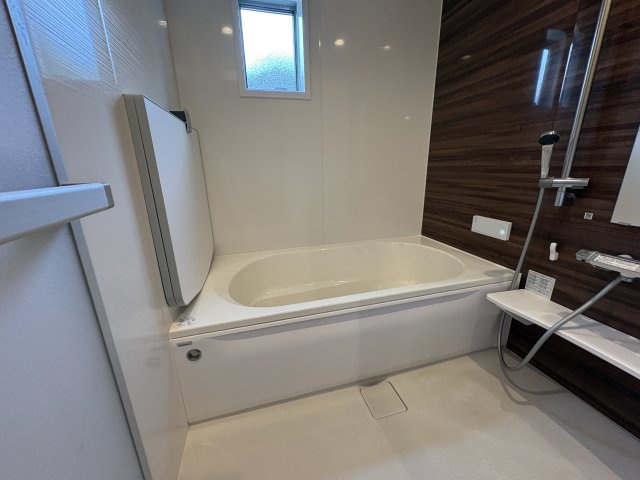 落ち着いた木目調アクセントパネルを採用した浴室です。足を伸ばしてゆったりくつろげる浴槽を備え一日の疲れを癒してくれます。窓付きのため換気もしやすく、湿気対策にも効果的。清潔感のある快適なバスルームです