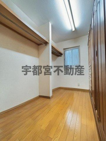 【収納】現地写真(一部荷物をCG加工にて削除しております)：ゆとりの広さのウォークインクローゼット。タンスを置いても一面が見渡せてスッキリと広く使えます。