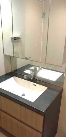 シャワー水栓が設置された三面鏡の洗面台です