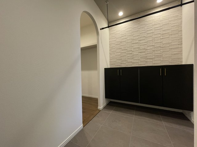 玄関から続くウォークスルークローゼット。出入口は流行りのアーチ仕様に。