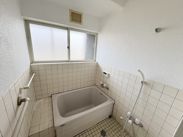タイル張りで清潔感のある浴室は、窓付きで換気がしやすく、湿気がこもりにくい設計。自然光が入るため、日中は明るく安心して利用できます。手すりも設置されており、お子様やご高齢の方にも配慮された空間。