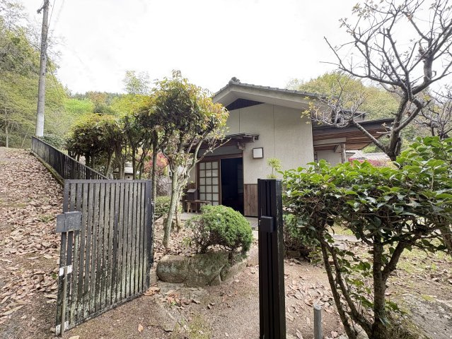 趣ある門扉と植栽が印象的なアプローチ部分です。外観は落ち着いた和の佇まいで、周囲の自然と調和した住まいです。門から玄関までの動線も確保されており、プライバシー性の高さも魅力となっています。