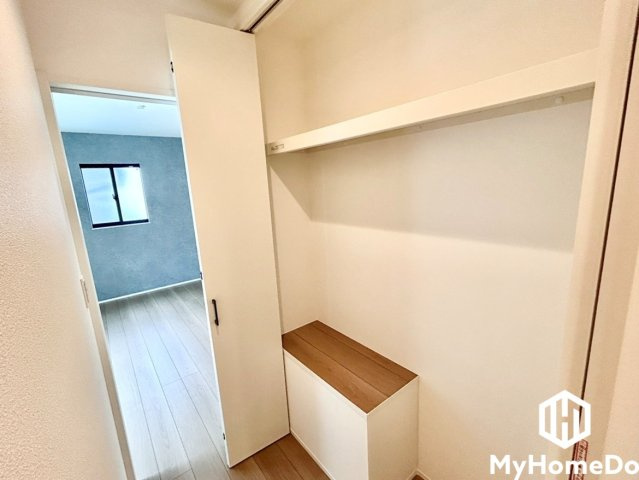 手前下部には木天板の収納キャビネットが配置されており、小物の保管や一時的な荷物置き場として重宝します。