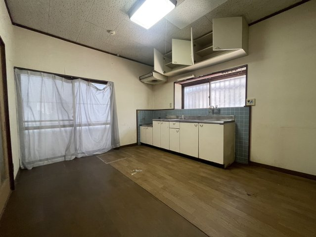 壁付けのコンパクトなキッチンは、シンプルながら使い勝手に配慮された設計。上下に収納スペースがあり、調理器具や調味料などを効率よく整理できます。窓があり、自然光が差し込む明るい空間になっています。