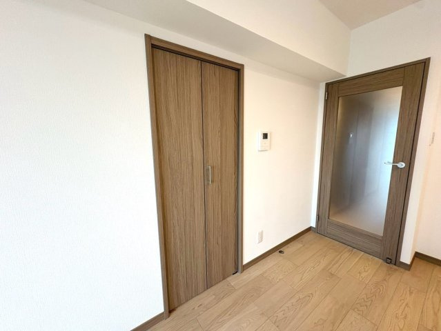 採光性のあるリビングドアを採用し、木目の収納と調和した温もりある住まいです