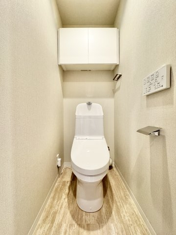 白を基調とした収納棚付きトイレです。