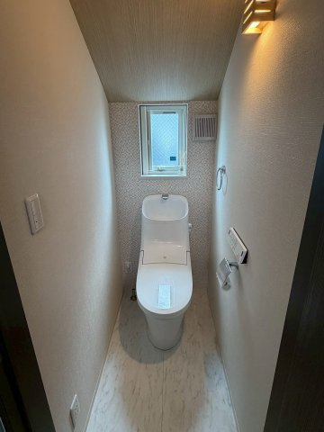 空間をすっきり見せるタンクレストイレです。個別の手洗い器と鏡が設置されており、ゲストが使用する際にも便利。小窓からの採光と柔らかな照明が、落ち着きのあるクリーンな空間を演出します！