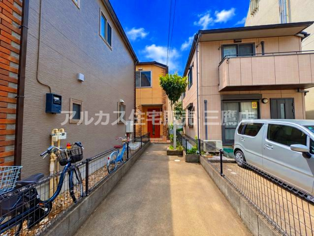 道路から玄関へと続くアプローチ部分。前面道路からの奥行きがあり、プライベート感を高めた落ち着いた敷地配置となっています。