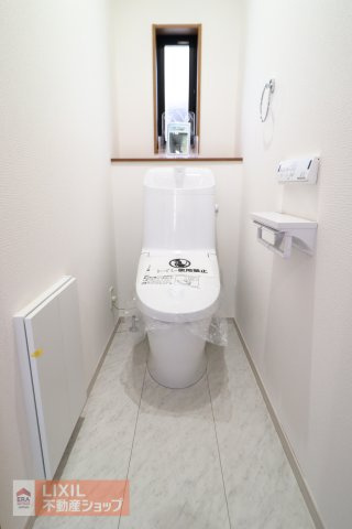 【トイレ】現地完成写真。温水洗浄暖房便座付き。小窓がついており採光と換気ができるようになっています。2階にもトイレがございます。