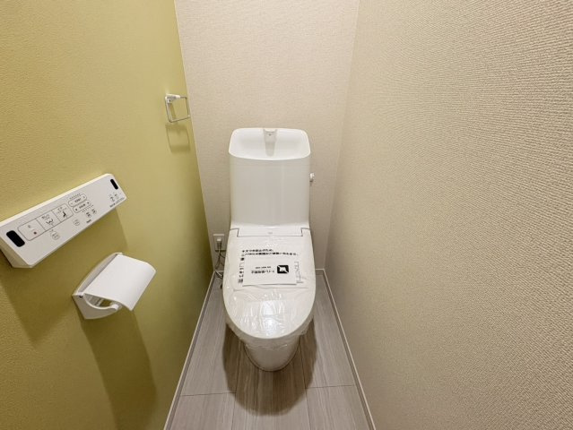 白基調の空間にグリーンのアクセントクロスがお洒落で落ち着いた雰囲気のトイレ。