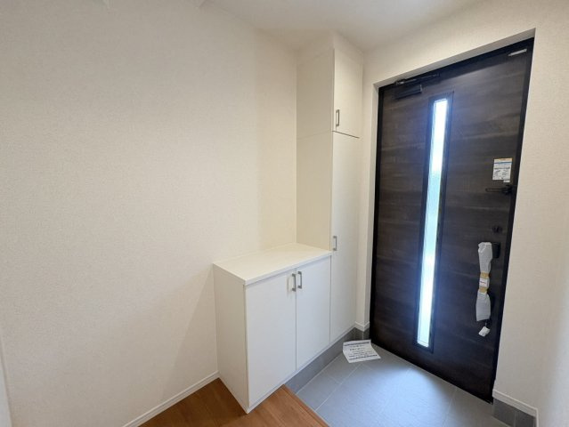 採光ドアからやさしい光が差し込む明るい玄関。収納付きで、いつでもすっきりとした空間を保てます。