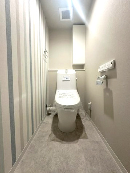 温水洗浄便座付のトイレで、冬の寒い時期でも快適！吊戸棚付きで、予備のペーパー類も問題なく収納できます。