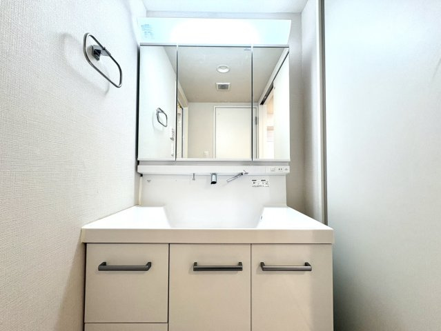 白を基調とした洗面化粧台。　三面鏡収納付きで、機能性と美しさを兼ね揃えた空間です。