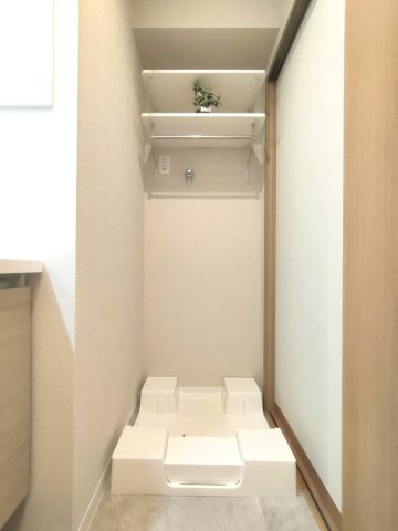 【室内洗濯機置き場】　壁面に棚が造作されています。洗剤のストックやタオルなどを収納できます。