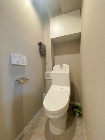 快適なウォシュレット機能を備えた新規交換済みの清潔なトイレ空間。毎日使う場所だからこそ、衛生面と居心地の良さにこだわりました。上部に収納スペースもあり、用品もすっきり収まります。