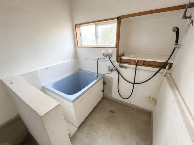 換気窓を備えた浴室。装飾のないシンプルな深型の浴槽を採用