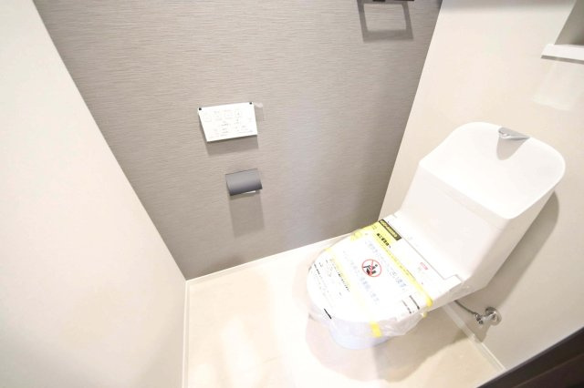アクセントクロスに彩られたトイレは温水洗浄機能付きです