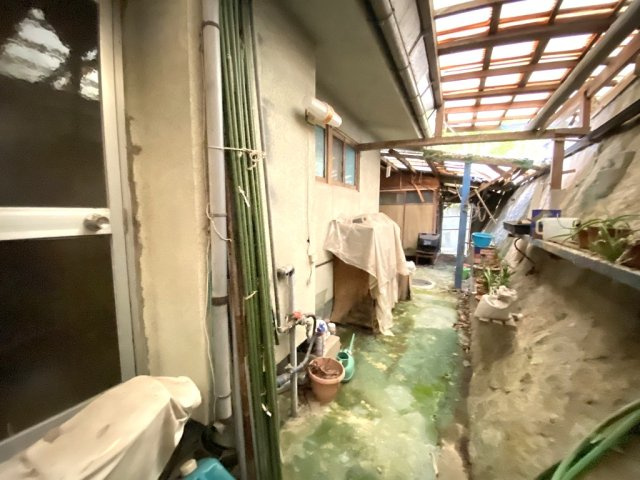 住まいの裏手には屋根付きの通路があり、雨の日の作業や物置としても活用できる便利な空間です。植栽や鉢植えの管理にも適しており、趣味の場としても活躍します。日常と特別な時間を両立できる魅力的な住まいです。