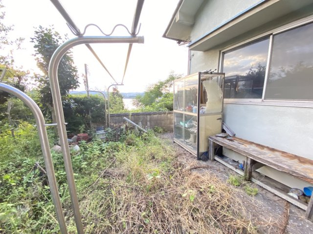 裏庭からは海を望むことができ、ガーデニングや家庭菜園を楽しむのに最適なスペースです。現在は自然が豊かに茂っていますが、整備すれば憩いの庭として再生可能。潮風を感じながらくつろぎの時間を過ごせます。