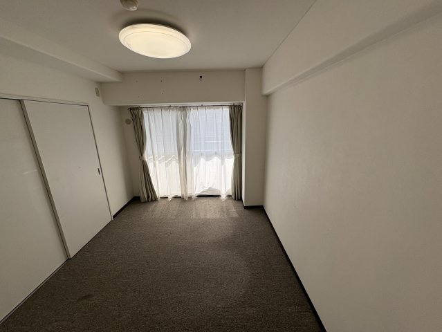 やわらかな色合いの壁と落ち着いた雰囲気が魅力の洋室。デスクや収納棚を置いても十分なスペースがあり、子供部屋や趣味の部屋など幅広く活用できます。仕切りカーテンを活用し、空間を柔軟に区切ることも可能です。