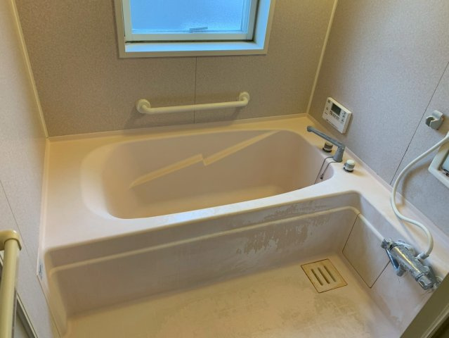 手すりと窓が設置された、足が伸ばせる仕様の浴槽です。