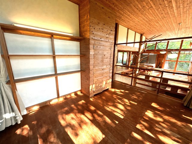 前写真と同室。喰壁を活かした本棚。隠し扉の先に広がる大容量の収納が、秘密基地の　ような遊び心を灯す。