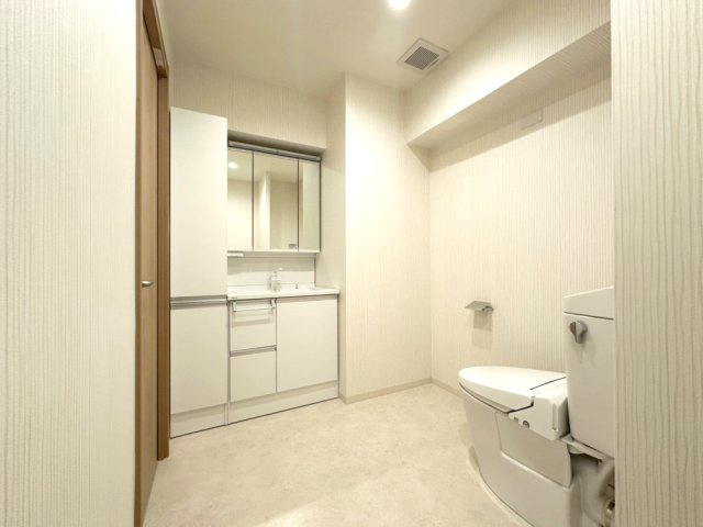 約11帖の洋室からつながる化粧室。脱衣室にあるものと同じ独立洗面台とトイレがあります。