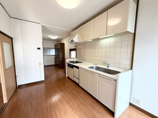 ゆとりある広さのダイニングキッチン。収納豊富なシステムキッチンを備え、作業スペースも広々としています。3口コンロ付きで同時調理が可能。動線が確保されており、家族での料理もスムーズに行えます。