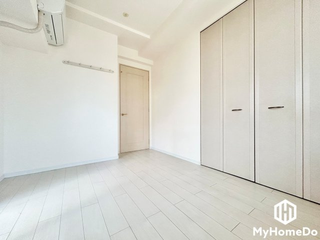 明るい光が広がる白いフローリングに、壁一面の大きなクローゼットが目を惹く洋室。　かさばるお洋服や荷物もたっぷりしまえるので、お部屋はいつでもスッキリ開放的。