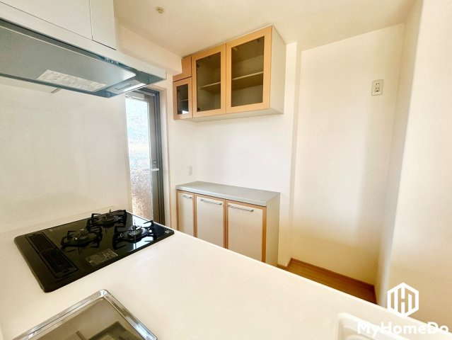 お部屋のテイストに美しくマッチする、備え付けの食器棚・カウンター収納を完備したキッチンです。奥にはバルコニーへ直接出入りできる勝手口があります。