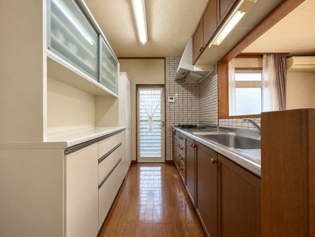 キッチンは作業場所と通路が分かれた使いやすい配置。勝手口が設けられており屋外へ直接出入りできるのもポイントです。LDKとつながりながらも、調理スペースをある程度独立させられる間取りとなっています。