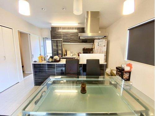 スタイリッシュなガラステーブルが映えるダイニングは、ゆとりある配置で家族団らんに最適。対面キッチンで会話も弾み、自然光も心地よく差し込む、快適な食卓空間です。