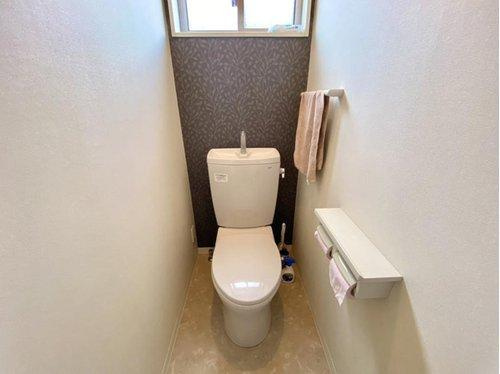 2階トイレは、植物柄のアクセントクロスが印象的なデザイン。窓付きで明るさと換気性を確保しつつ、シンプルで清潔感のある空間に仕上がっています。
