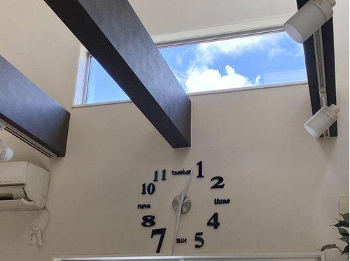 吹き抜け天井に設けられた横長の高窓から青空が望め、室内に明るさと開放感をもたらします。梁がアクセントとなり、デザイン性の高いリビング空間を演出しています。