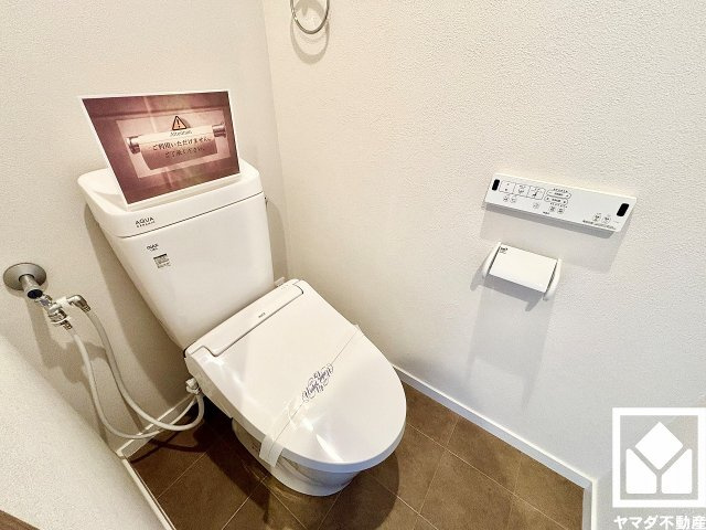 明るく清潔感溢れるトイレです。タオル掛けやペーパーホルダーが設置されています。