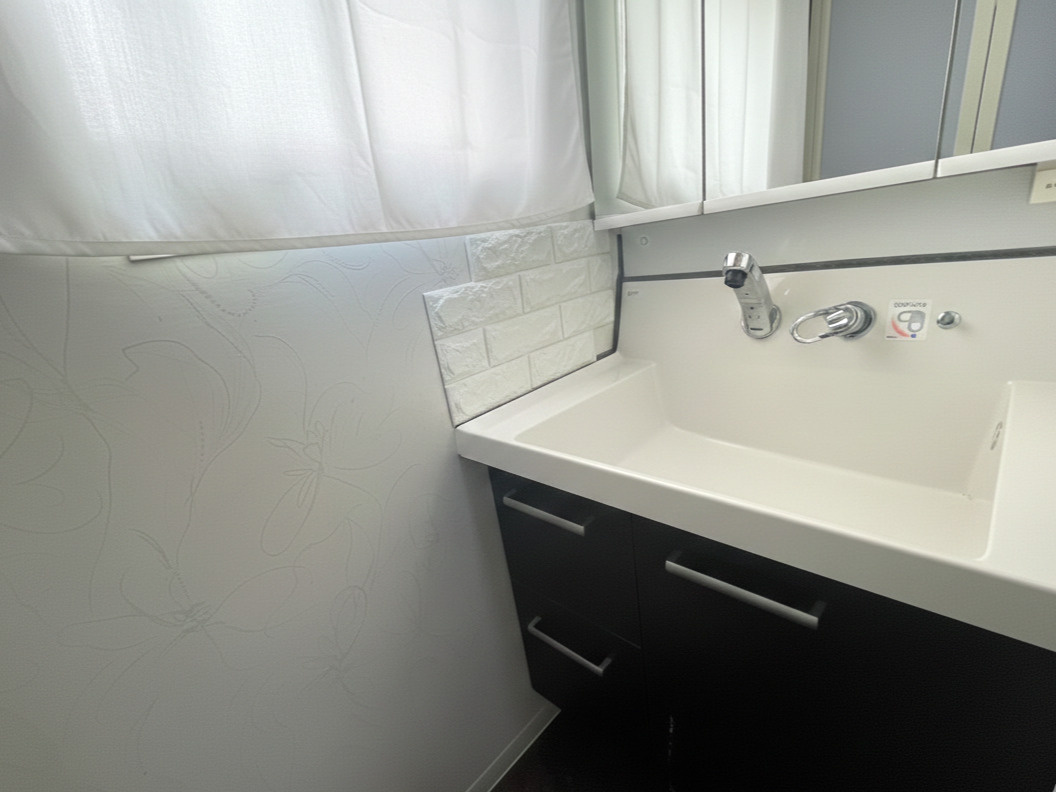 収納力のある洗面化粧台を採用。三面鏡タイプで身だしなみチェックもしやすく、鏡裏収納も備えています。カウンターは使いやすい広さを確保し、朝の準備もスムーズ。清潔感のあるデザインで、気持ちよく使える空間。