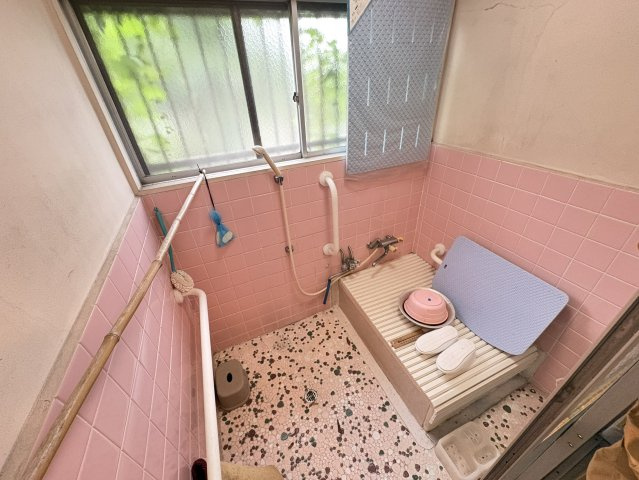 ピンクのタイルがレトロな雰囲気を醸し出す浴室は、窓付きでしっかり換気できる点が魅力。清潔感があり、毎日の入浴時間を快適に過ごせます。床は滑りにくい仕様で安心感もあり、手すりが設置されています。