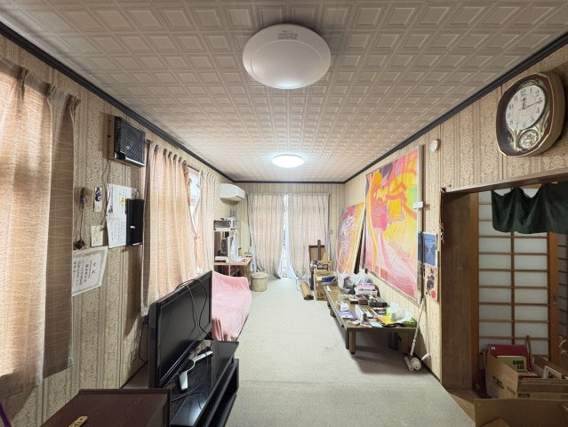 広々とした1階洋室は、大きな窓から自然光が差し込み明るく開放的な空間です。壁一面のアクセントアートが映え、趣味のスペースや家族の憩いの場としても活躍。縦長のレイアウトで家具配置の自由度が高いお部屋です