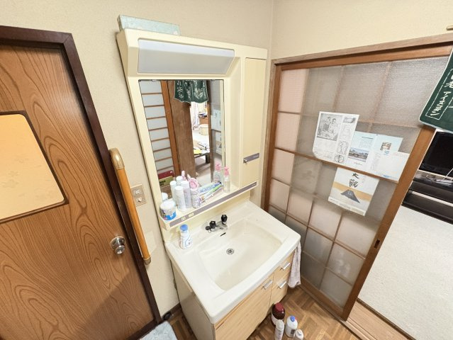 機能的な洗面台は鏡や収納が備わり、毎日の身支度を快適にサポートします。木の温もりを感じる建具や障子と調和し、和の雰囲気を大切にした住空間。玄関や浴室への動線も良く、家族みんなが使いやすい設計です。