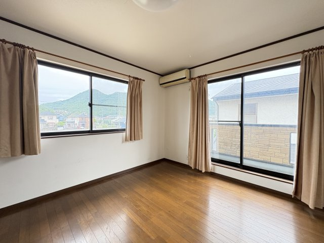 大きな窓から心地よい陽光が差し込む、明るい洋室です。