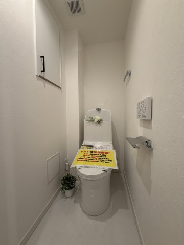 【空間をすっきり保つ便利な吊戸棚収納】　トイレットペーパーのストックや掃除用品などを生活感を隠してしまえる、黒い取っ手がアクセントの壁面収納を完備。