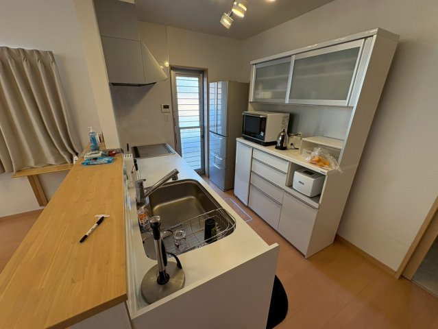 対面式キッチンで、通路幅に余裕があるため食器棚や家電収納を設置しやすい空間です。冷蔵庫や家電をまとめても動線を確保できます。勝手口付きでゴミ出しもスムーズです。使い勝手の良さが魅力です。